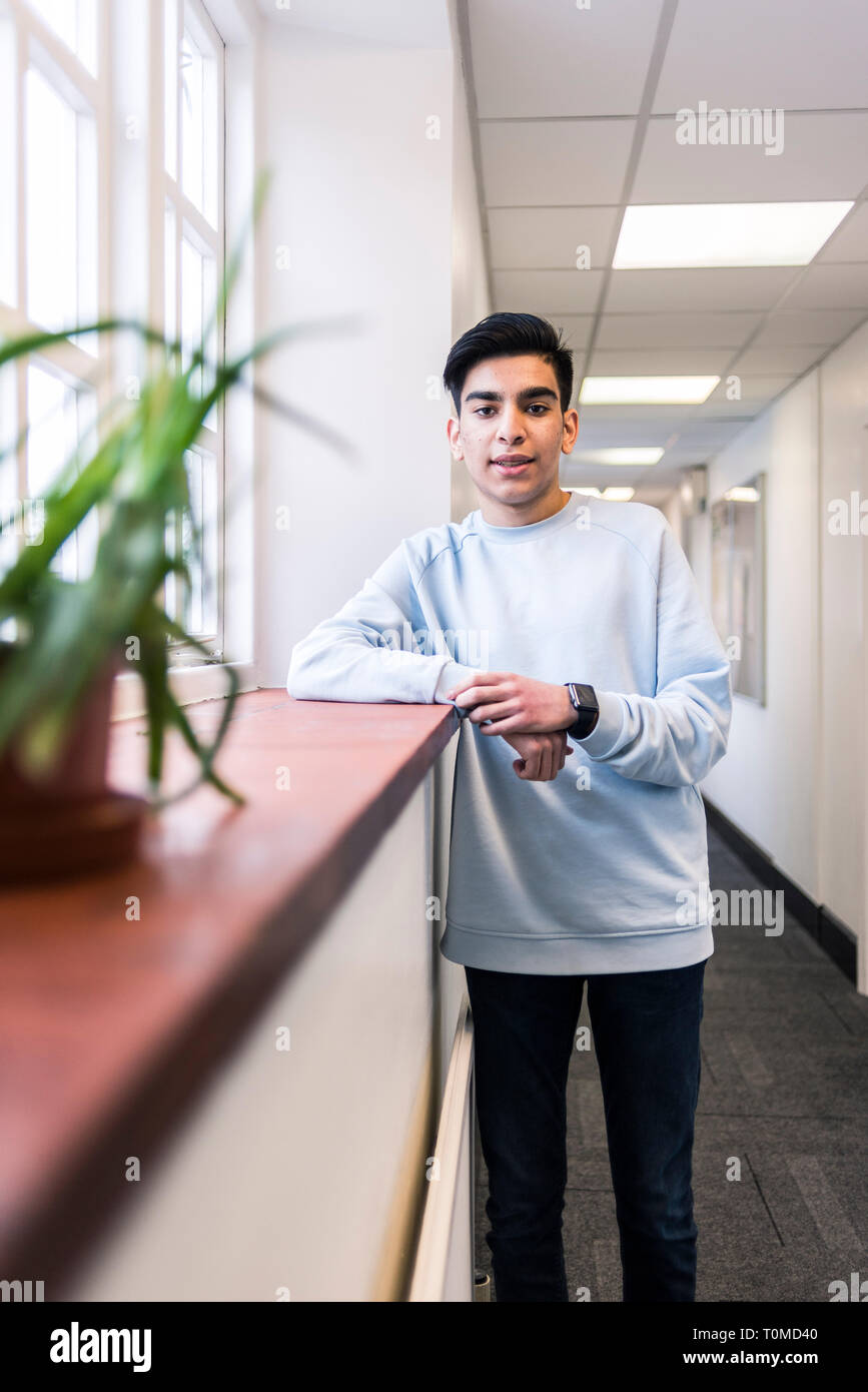 A middle eastern international student stands in the corridors of a cambridge collge Stock Photo