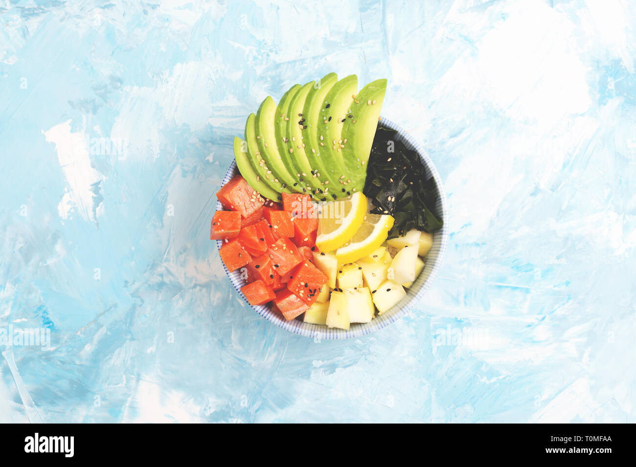 Hawaiian appetizer or main dish poke bowl on colorful background. Colorful food concept. Flat-lay, top view. Copy space for your text. Stock Photo