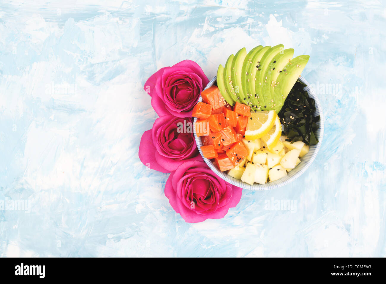 Hawaiian appetizer or main dish poke bowl on colorful background. Colorful food concept. Flat-lay, top view. Copy space for your text. Stock Photo