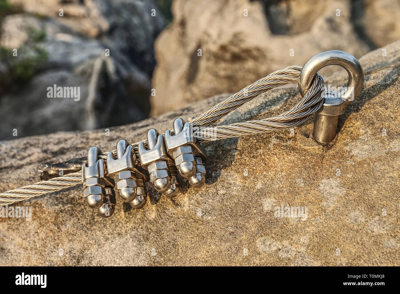 Mountain iron anchor for free climbing. Stainless cable fixed to the rock for the safety of the