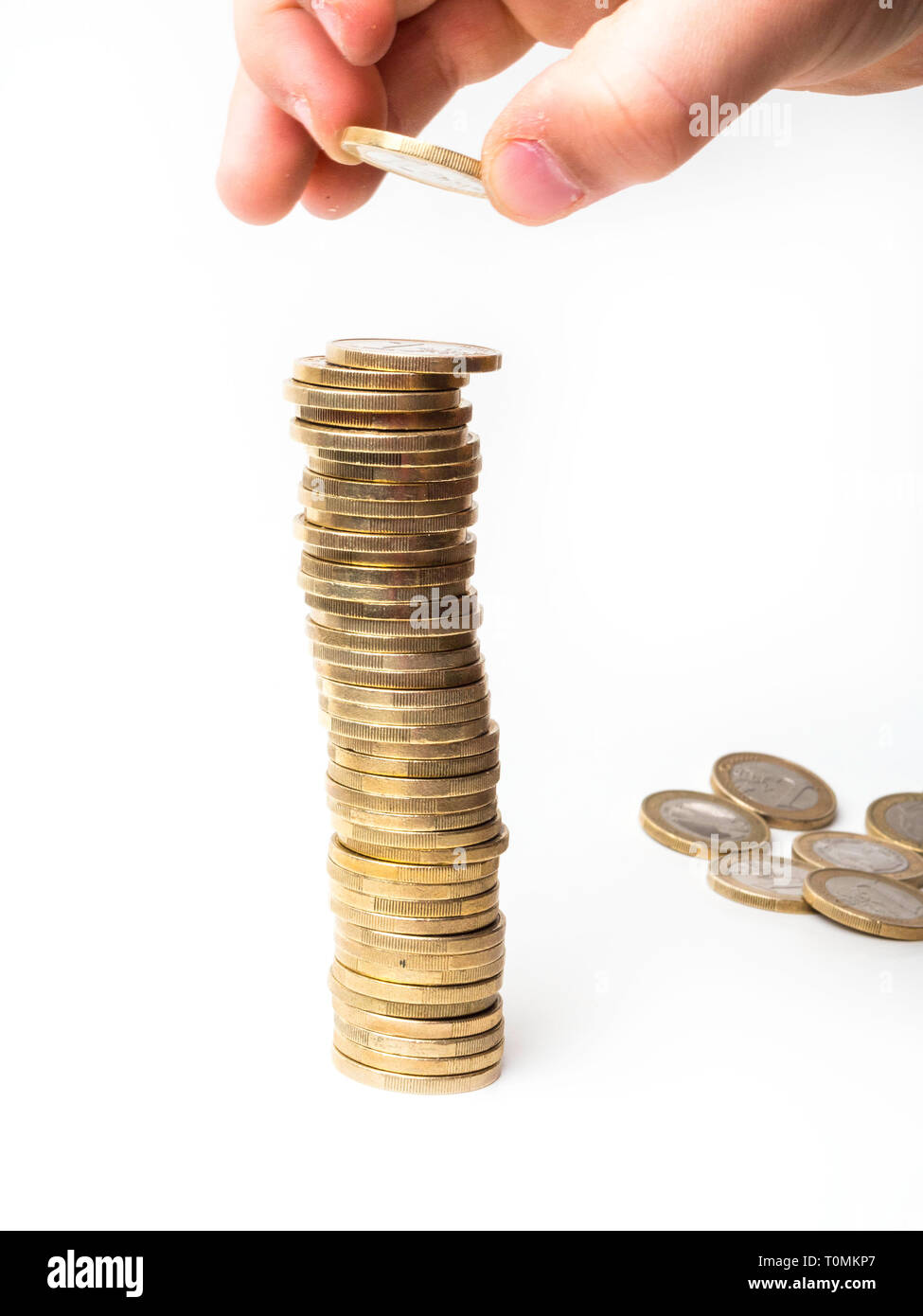 hand holding coins and building coin tower on white background Stock