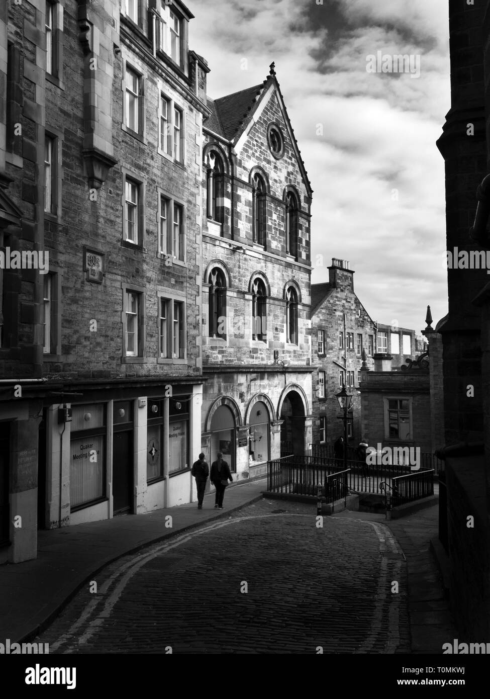 Two figures walking along Upper Bow off the Royal Mile in the Old Town in Edinburgh Scotland Stock Photo