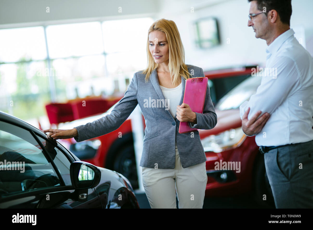 Professional salesperson during work with customer at car dealership