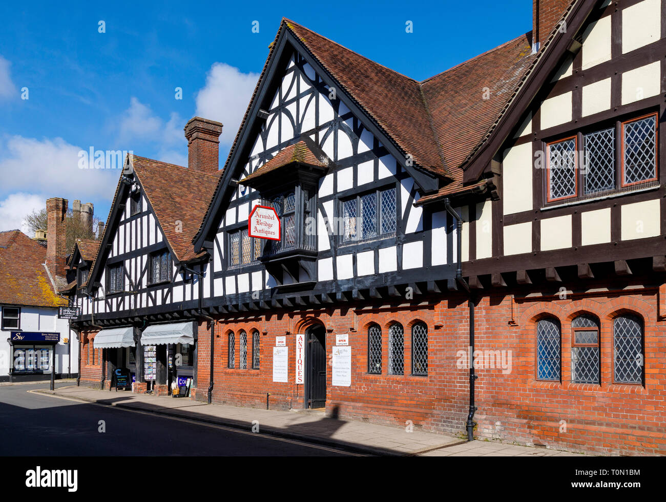 High Street, Arundel, West Sussex. Businesses within a mid C19 half timbered and red brick building with leaded windows and tiled roof. Stock Photo