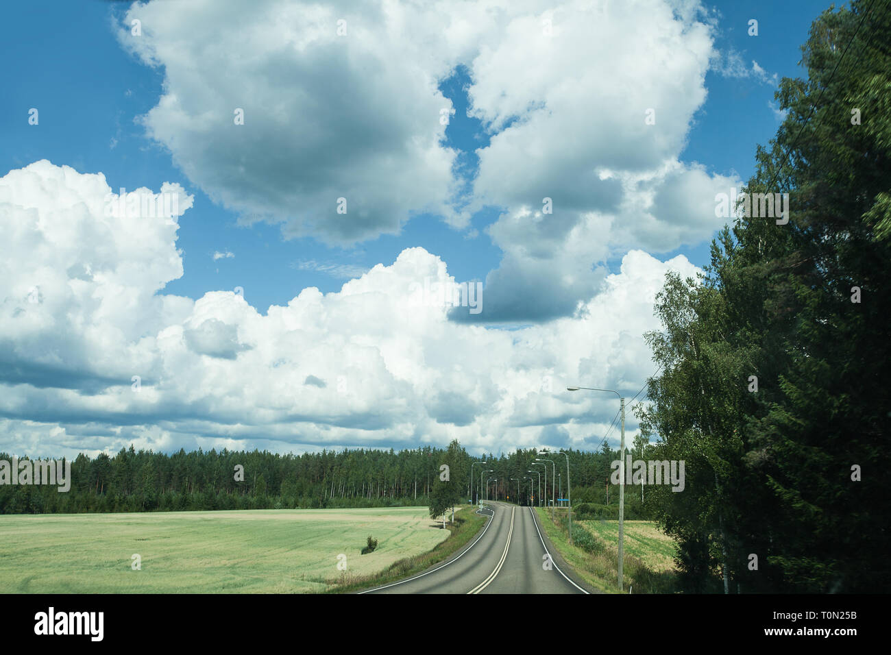 Fields, trees and road with blue sky and clouds Stock Photo - Alamy