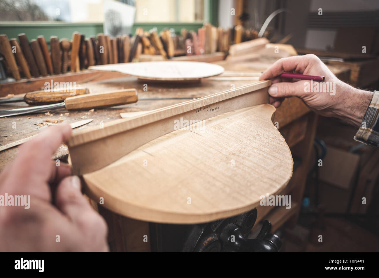 Instrument maker working on a piece of a mandolin Stock Photo