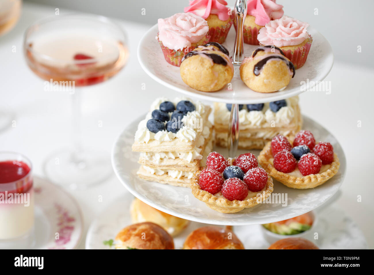 Afternoon tea with mini brioche canapes and selection of sweets Stock