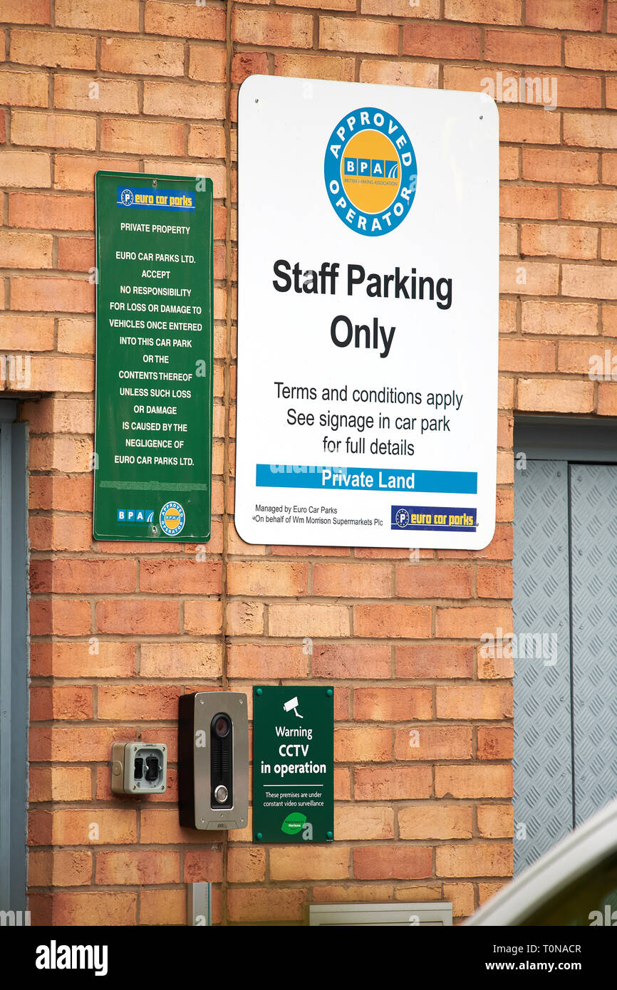 Notice on a brick wall informing the area is private land and a car park only for staff at a Morrisons supermarket. Stock Photo
