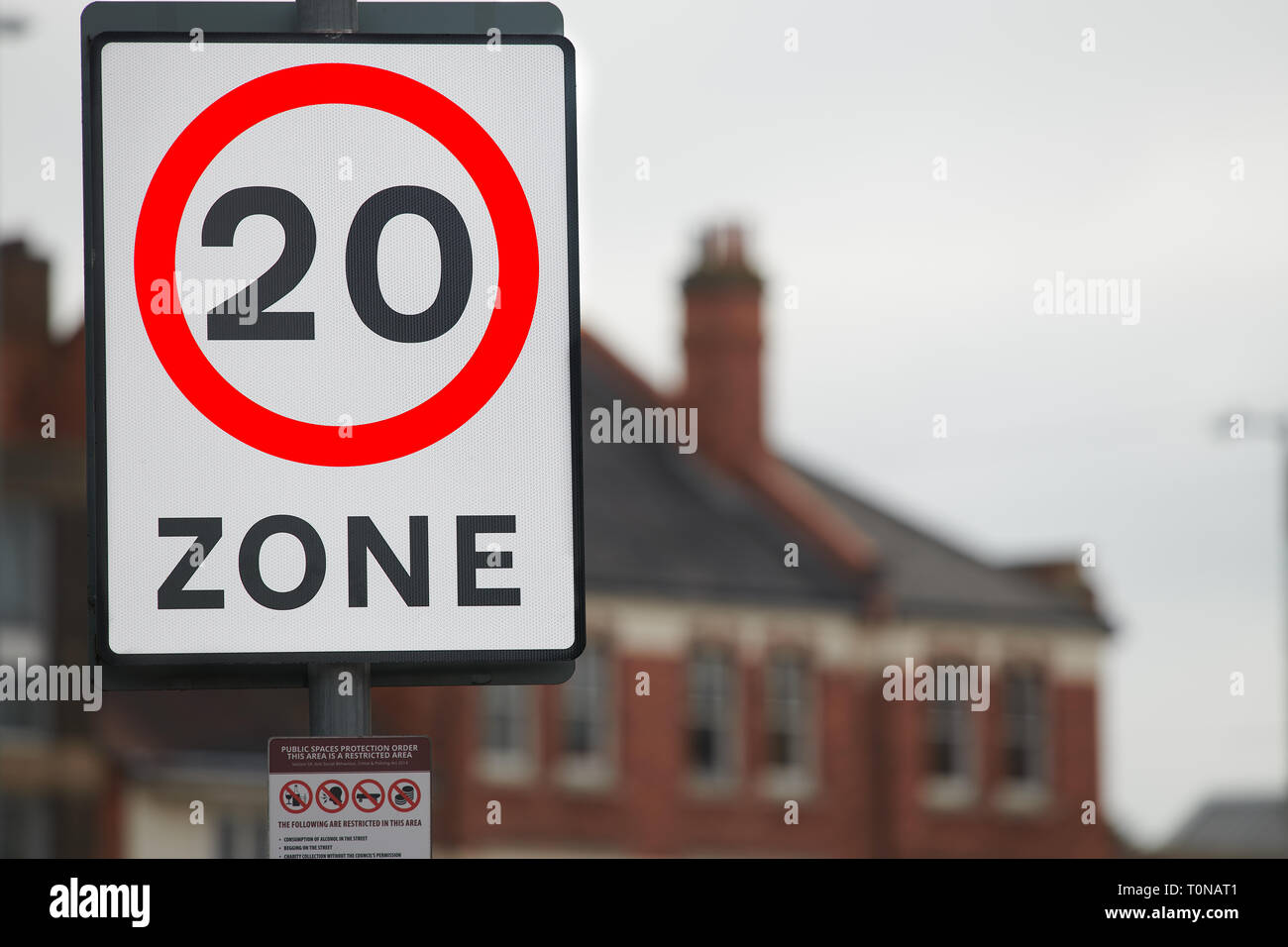 Information to motorists about a 20 mph restriction zone on a notice with a red perimeter circle and a black perimeter rectangle. Stock Photo