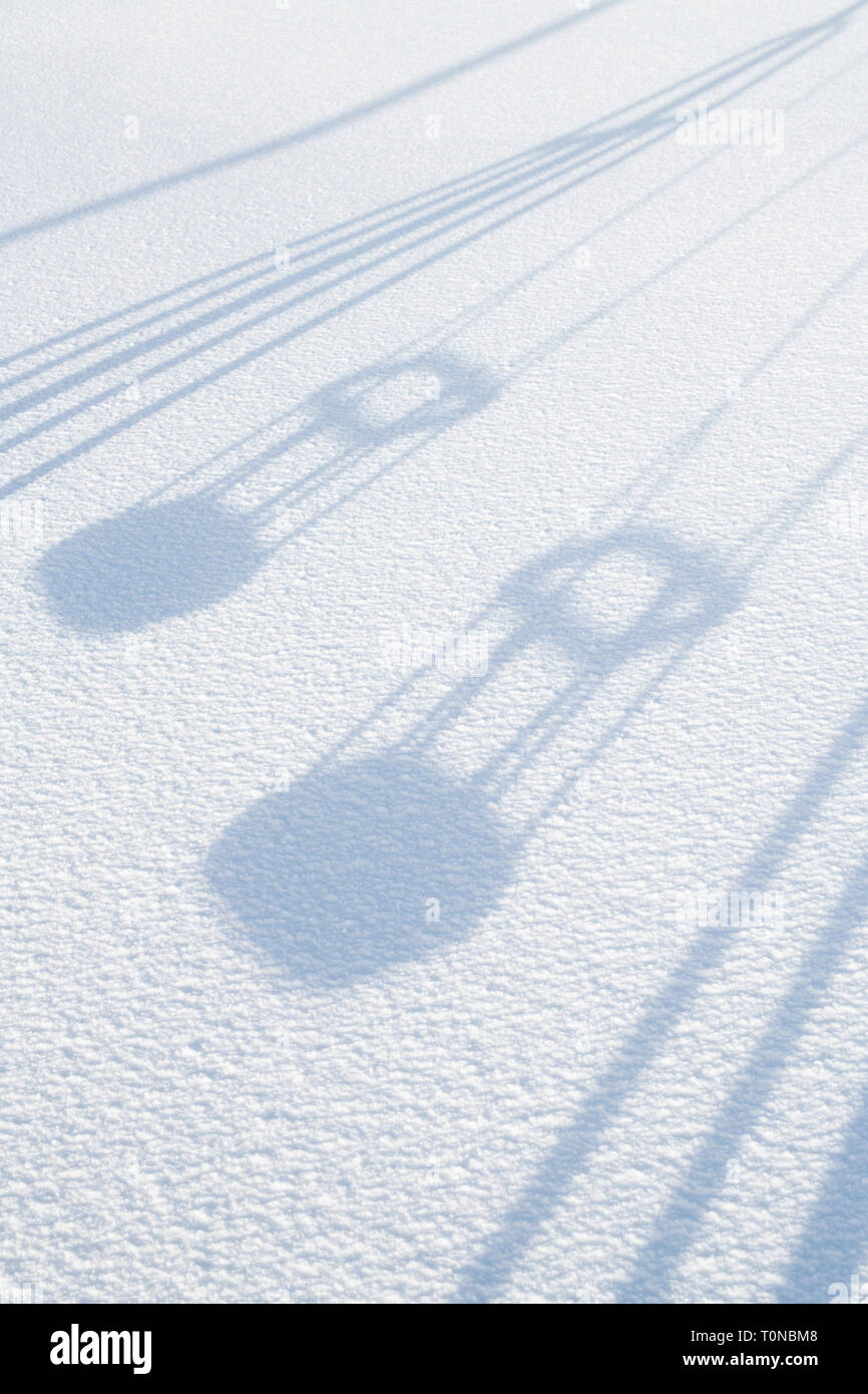 Playground swings shadow in Wanlockhead village in the morning snow. Scotlands highest village. Dumfries and Galloway, Scottish borders, Scotland Stock Photo