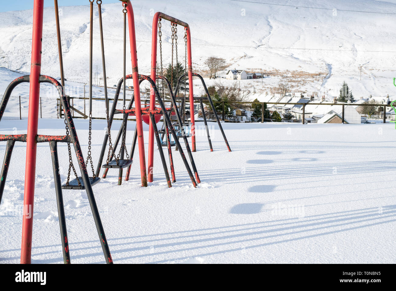 Playground swings in Wanlockhead village in the morning snow. Scotlands highest village. Dumfries and Galloway, Scottish borders, Scotland Stock Photo