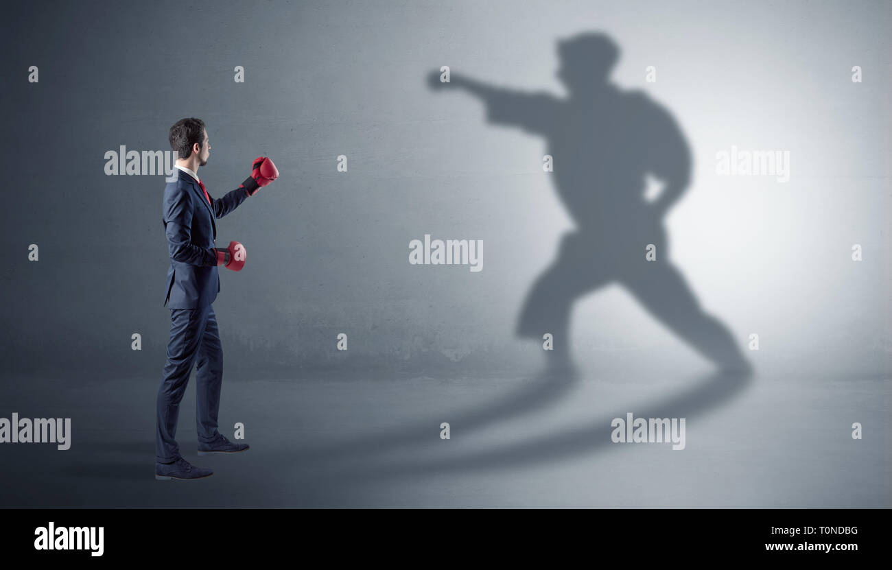 Businessman fighting with his strong karate man shadow  Stock Photo