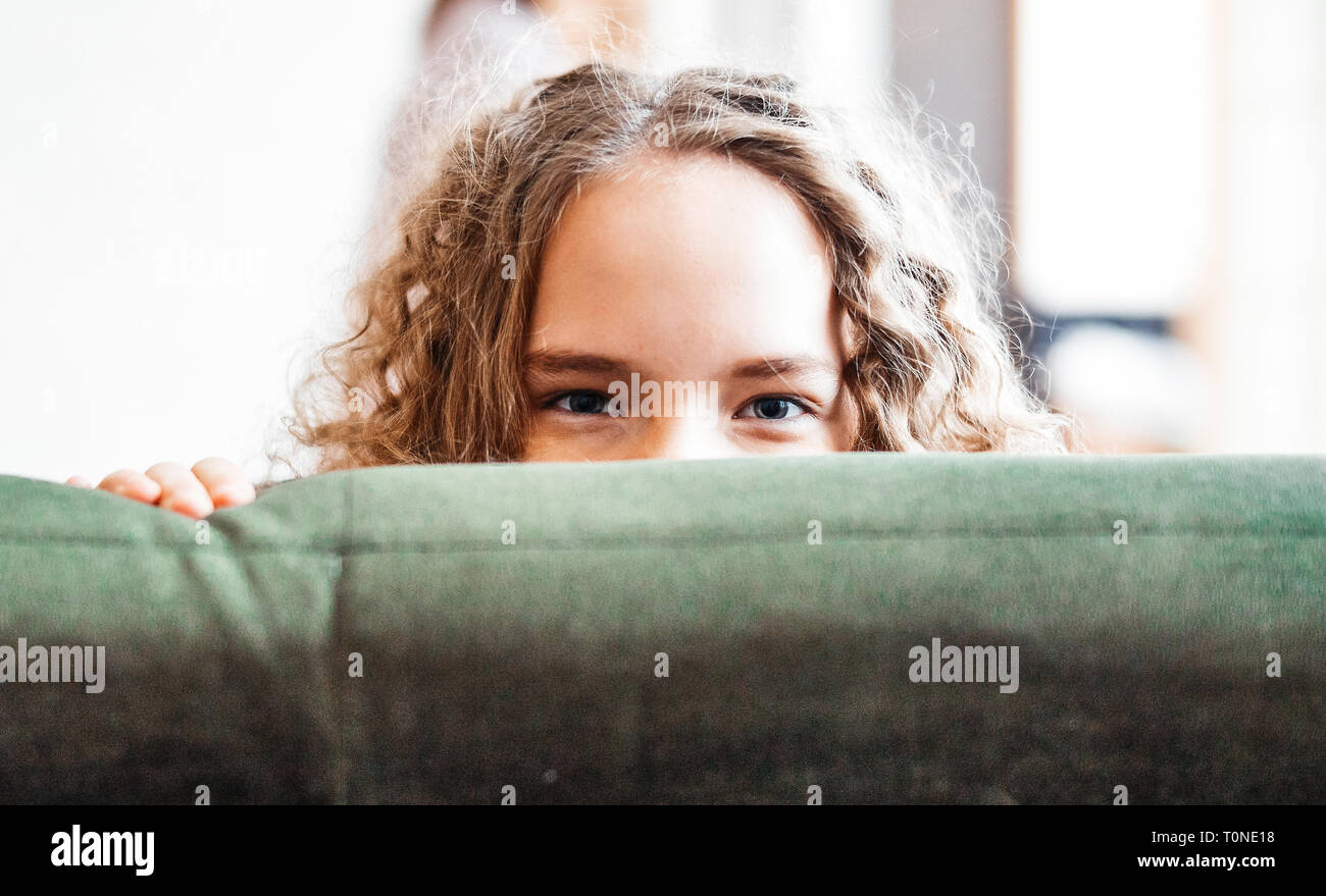 Young cute teenage girl sitting on green couch. Happy family concept. Stock Photo