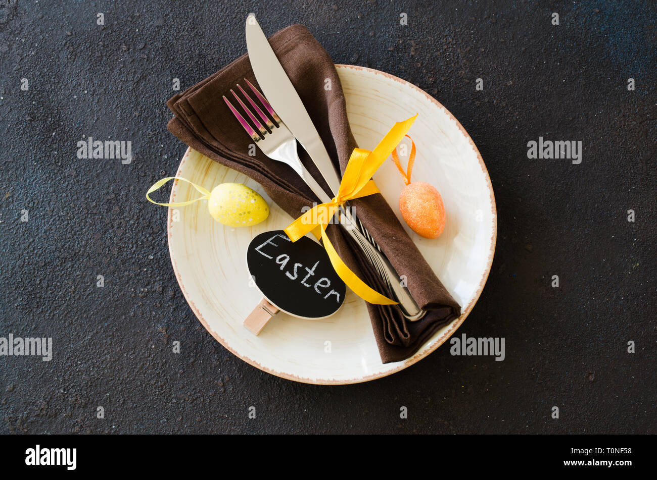 Festive table setting for holiday Easter dinner on dark table. Holidays background with copy space. Stock Photo