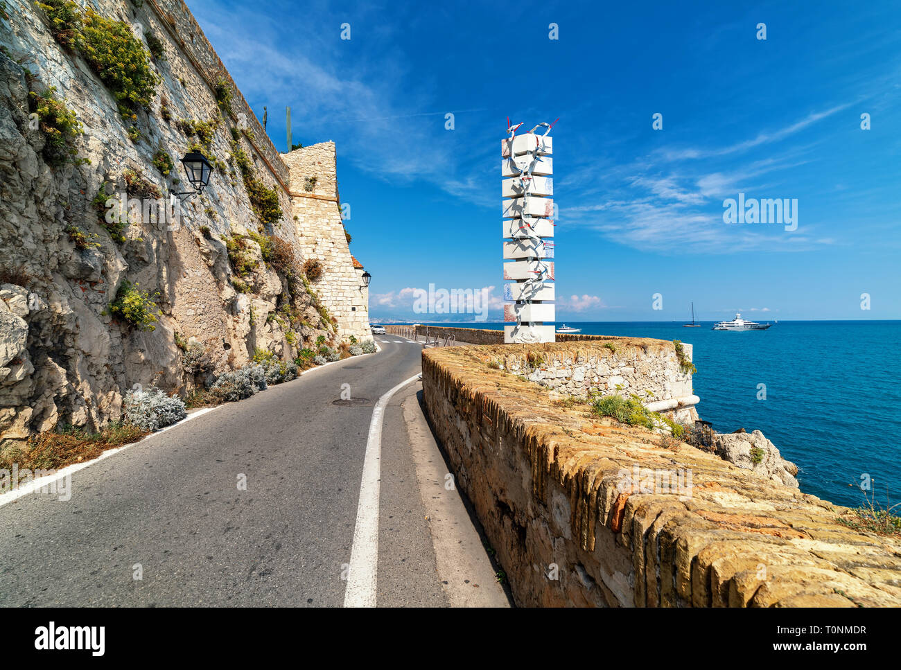 Narrow asphalt road along Mediterranean sea in Antibes, France. Stock Photo
