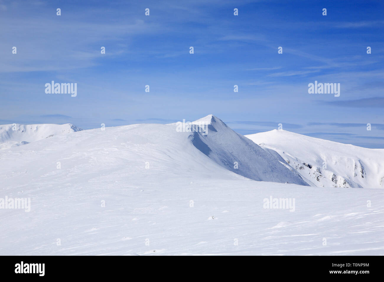 The mountains are covered with snow under a bright blue sky Stock Photo ...