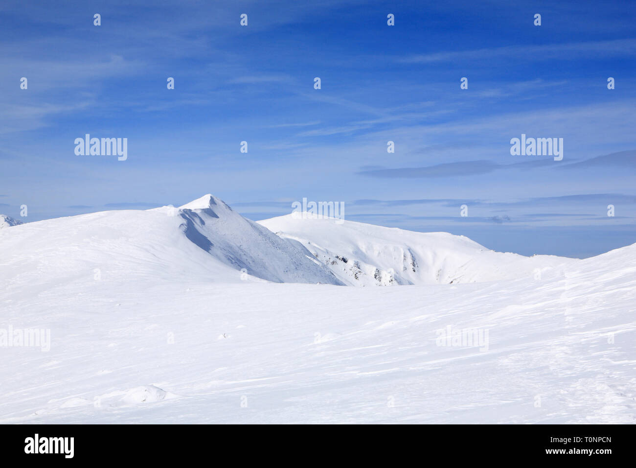 The mountains are covered with snow under a bright blue sky Stock Photo ...