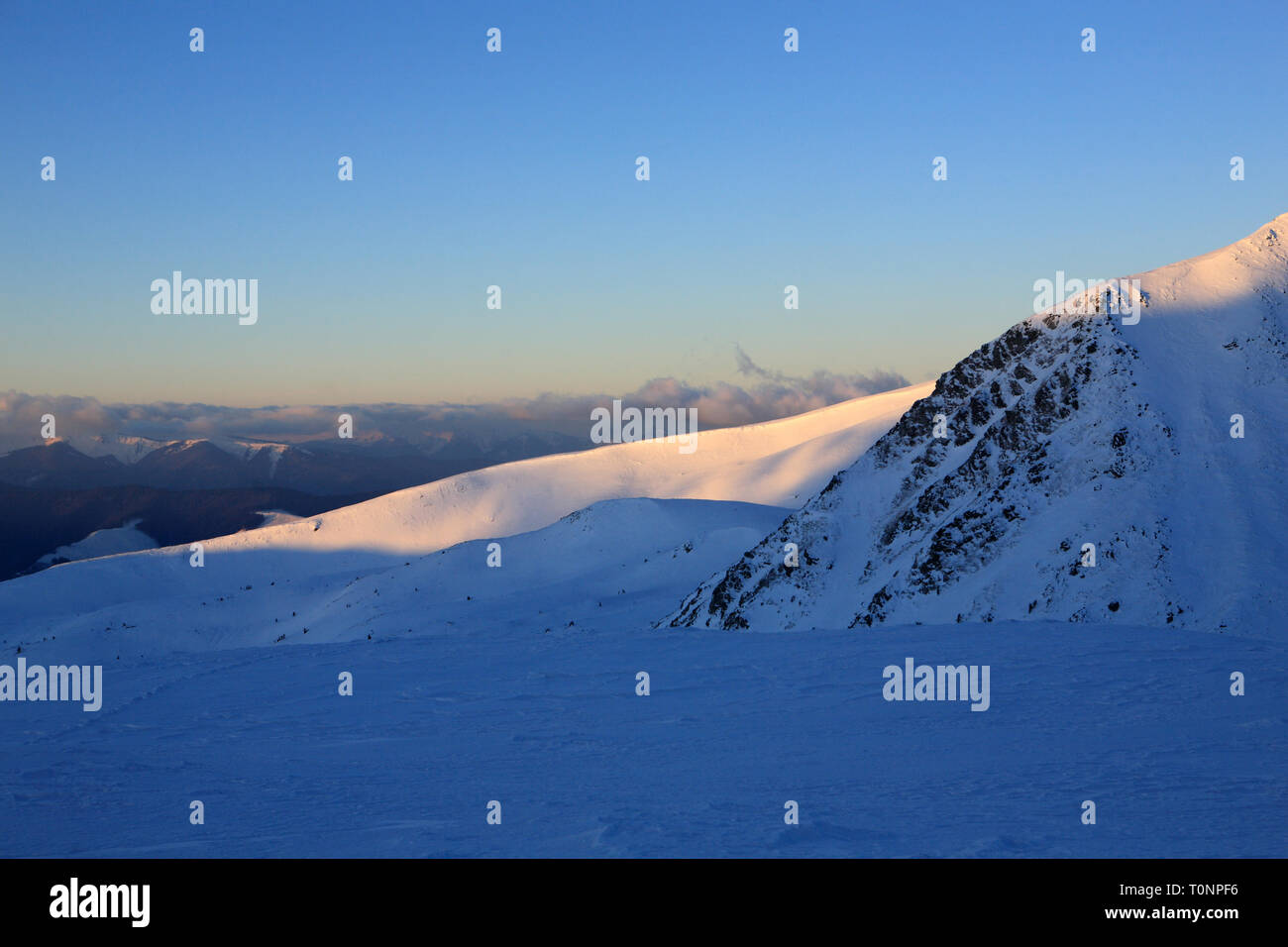 The first rays of the sun illuminate the top of the mountain ...