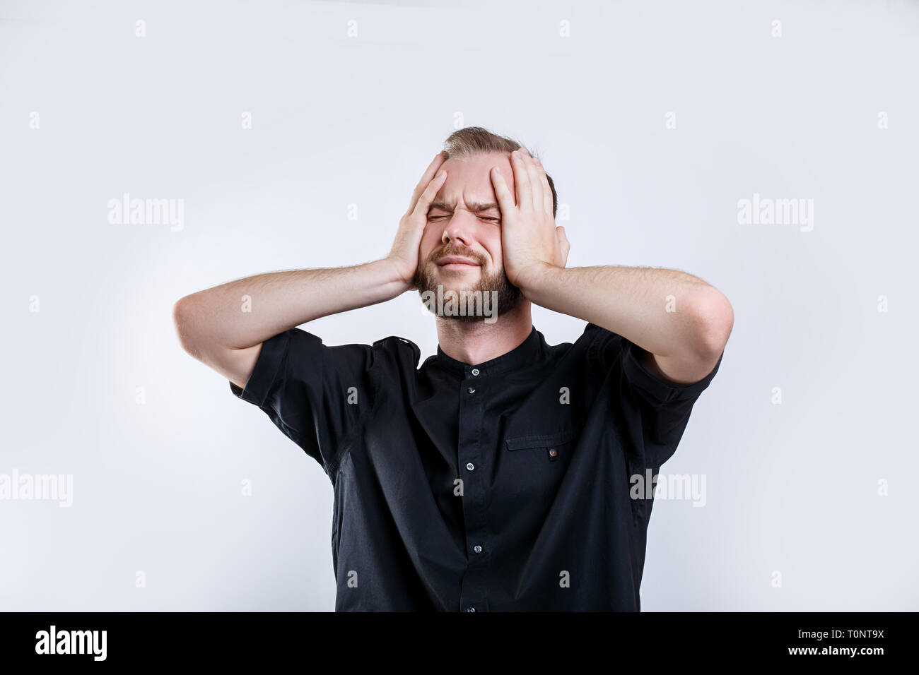 Portrait of worried bearded young man with closed eyes .Stressed young businessman Stock Photo