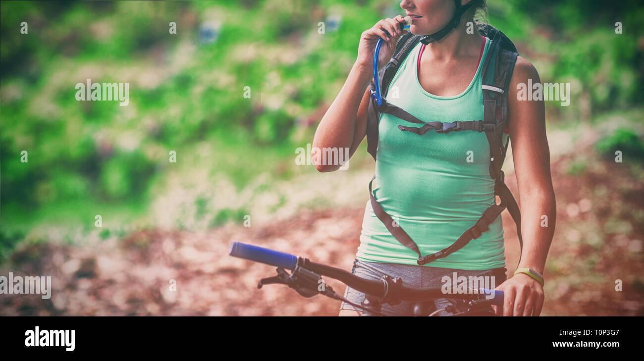 Female athletic drinking water from hydration pack Stock Photo