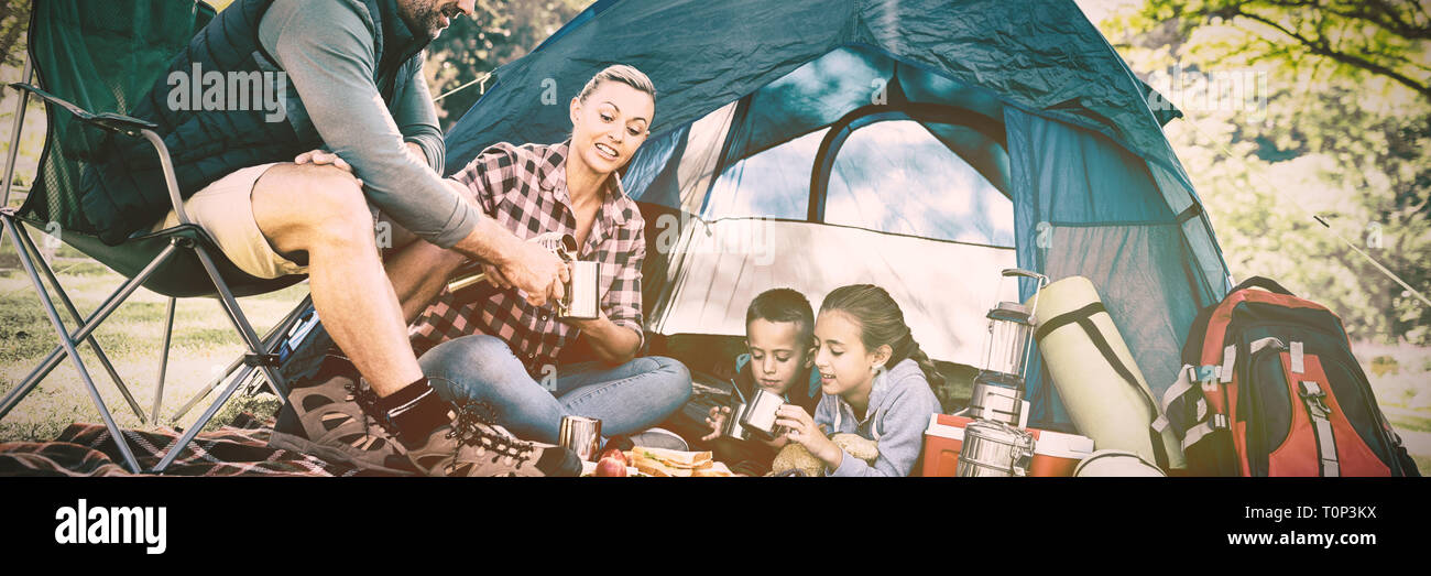 Family having snacks and coffee outside the tent Stock Photo