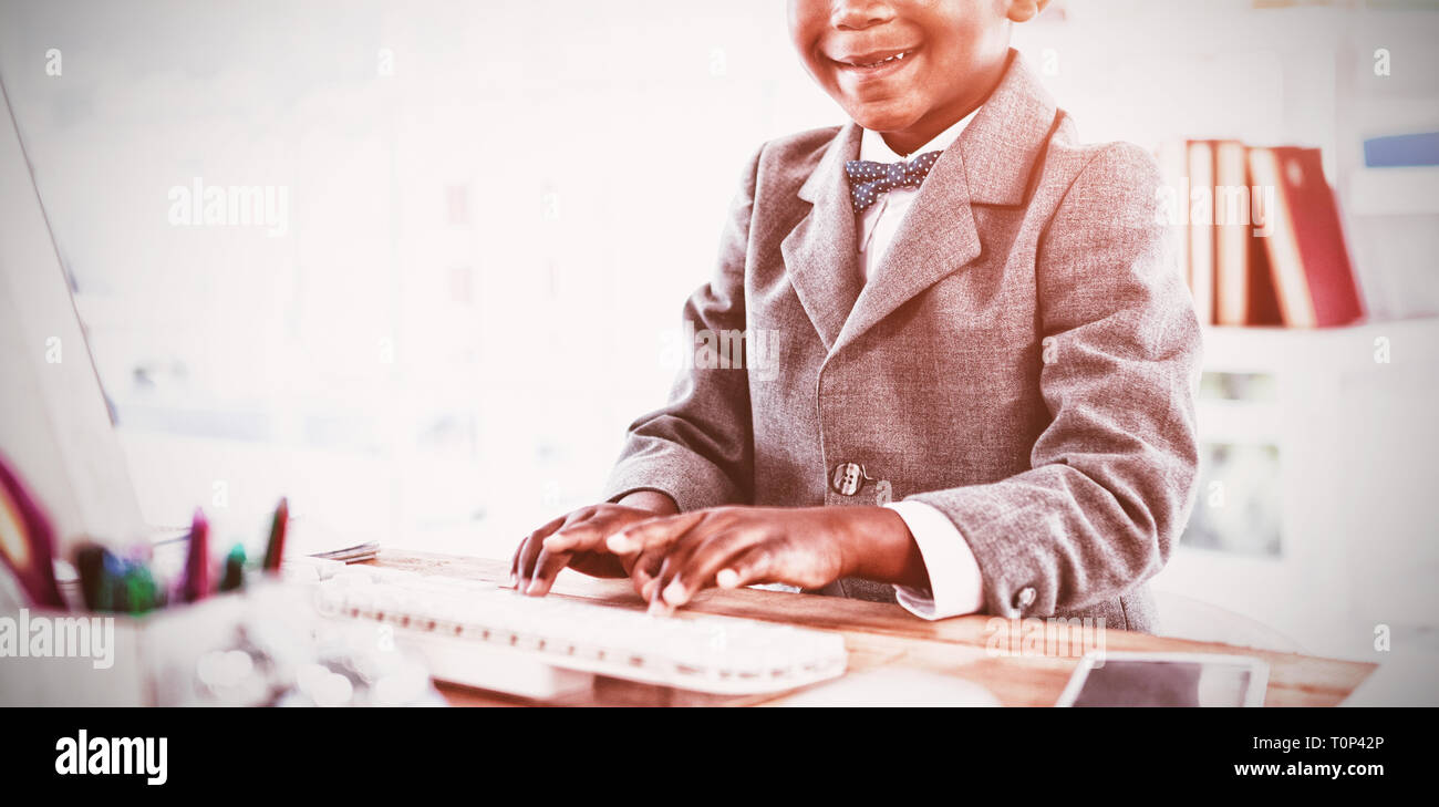 Portrait of boy imitating as businessman using computer Stock Photo