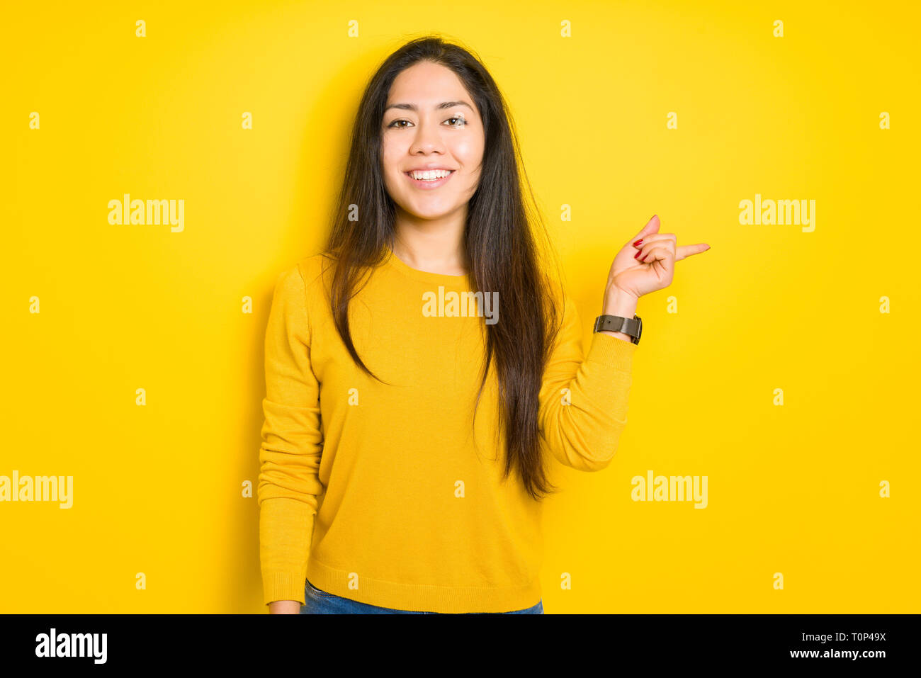 Beautiful brunette woman over yellow isolated background with a big ...
