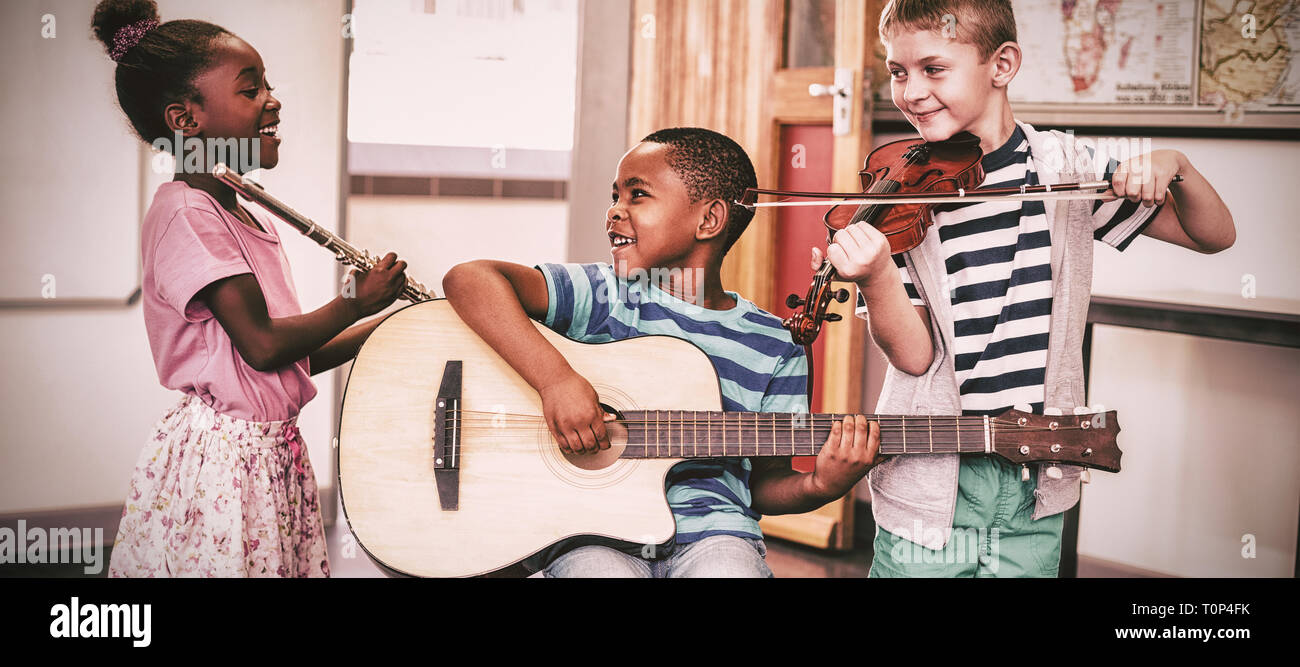 Children playing musical instruments in classroom Stock Photo