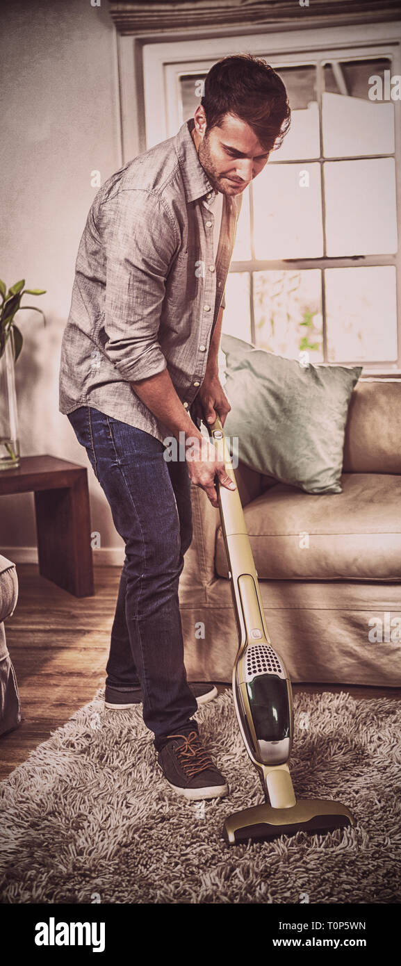 Man cleaning a carpet with a vacuum cleaner Stock Photo Alamy