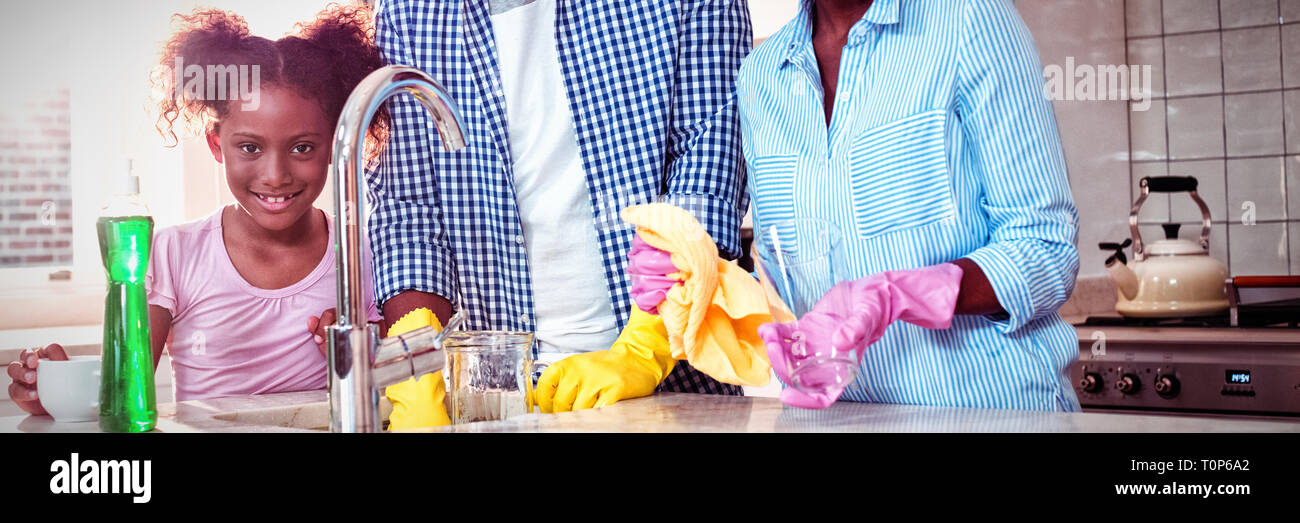 Portrait of family washing utensils in kitchen sink Stock Photo