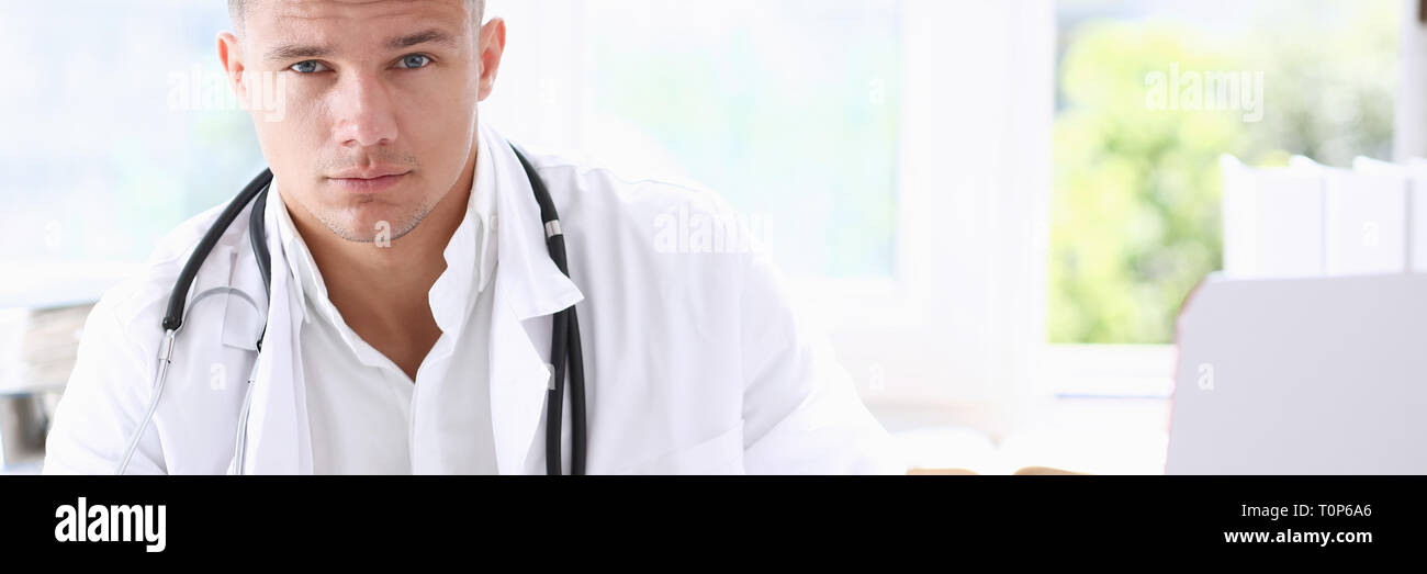 Handsome smiling male doctor sit at Stock Photo - Alamy