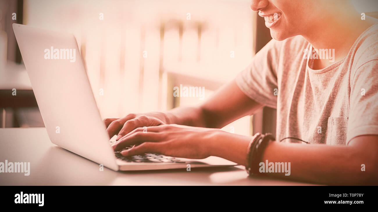 Happy schoolboy using laptop in classroom Stock Photo - Alamy