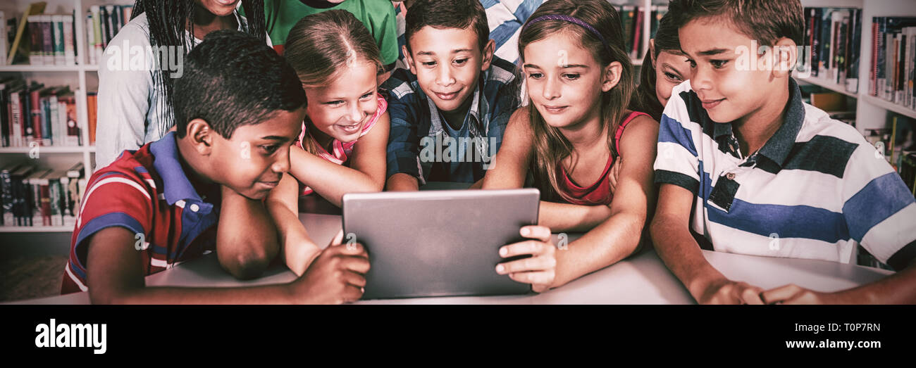Front view of pupils using tablet pc Stock Photo