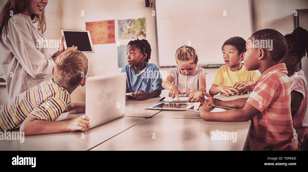 Teacher giving lesson with digital tablet Stock Photo