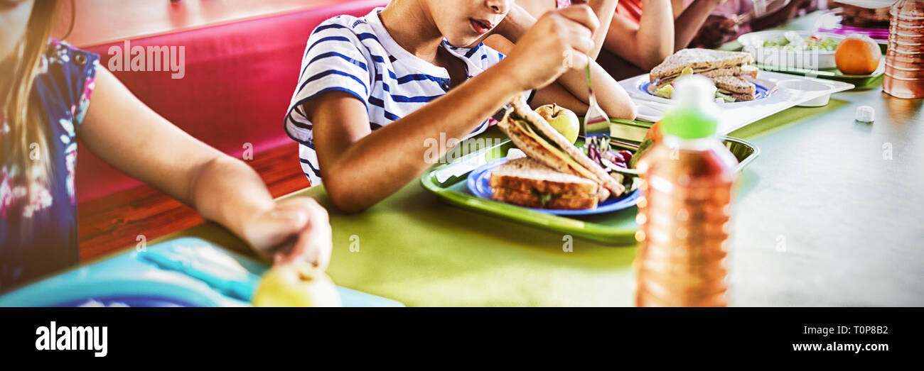 A group of cheerful small school kids in canteen, eating lunch. Stock Photo  by ©halfpoint 298162064