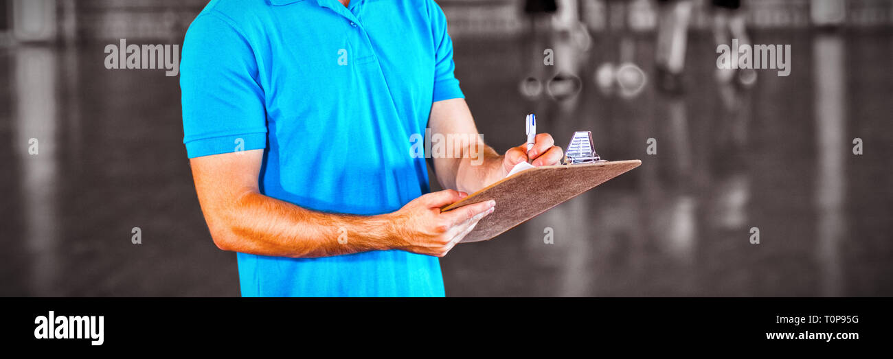 Portrait of sports teacher writing on clipboard Stock Photo
