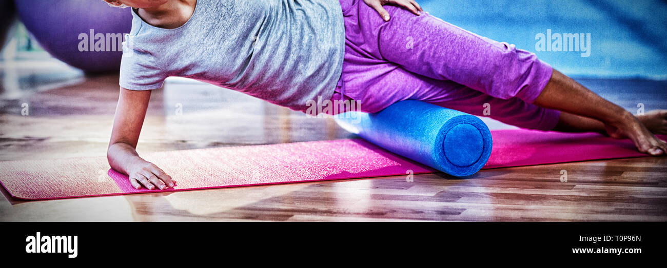 Woman performing exercise using foam roll Stock Photo - Alamy