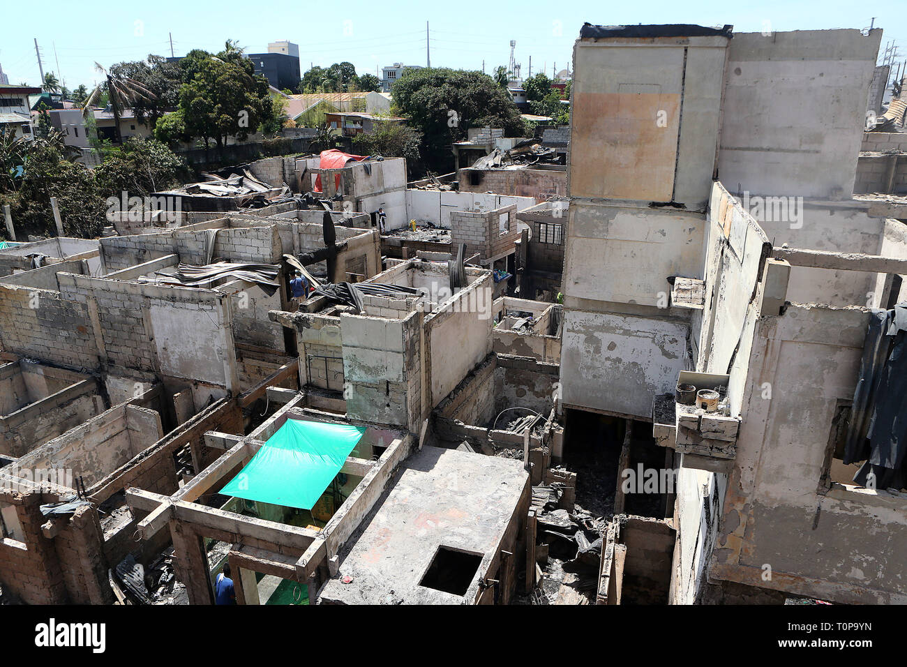Quezon City, Philippines. 21st Mar, 2019. Charred concrete frames of homes are seen after a fire at a slum area in Quezon City, the Philippines, March 21, 2019. More than 250 shanties were razed in the fire, leaving 750 families homeless. Credit: Rouelle Umali/Xinhua/Alamy Live News Stock Photo