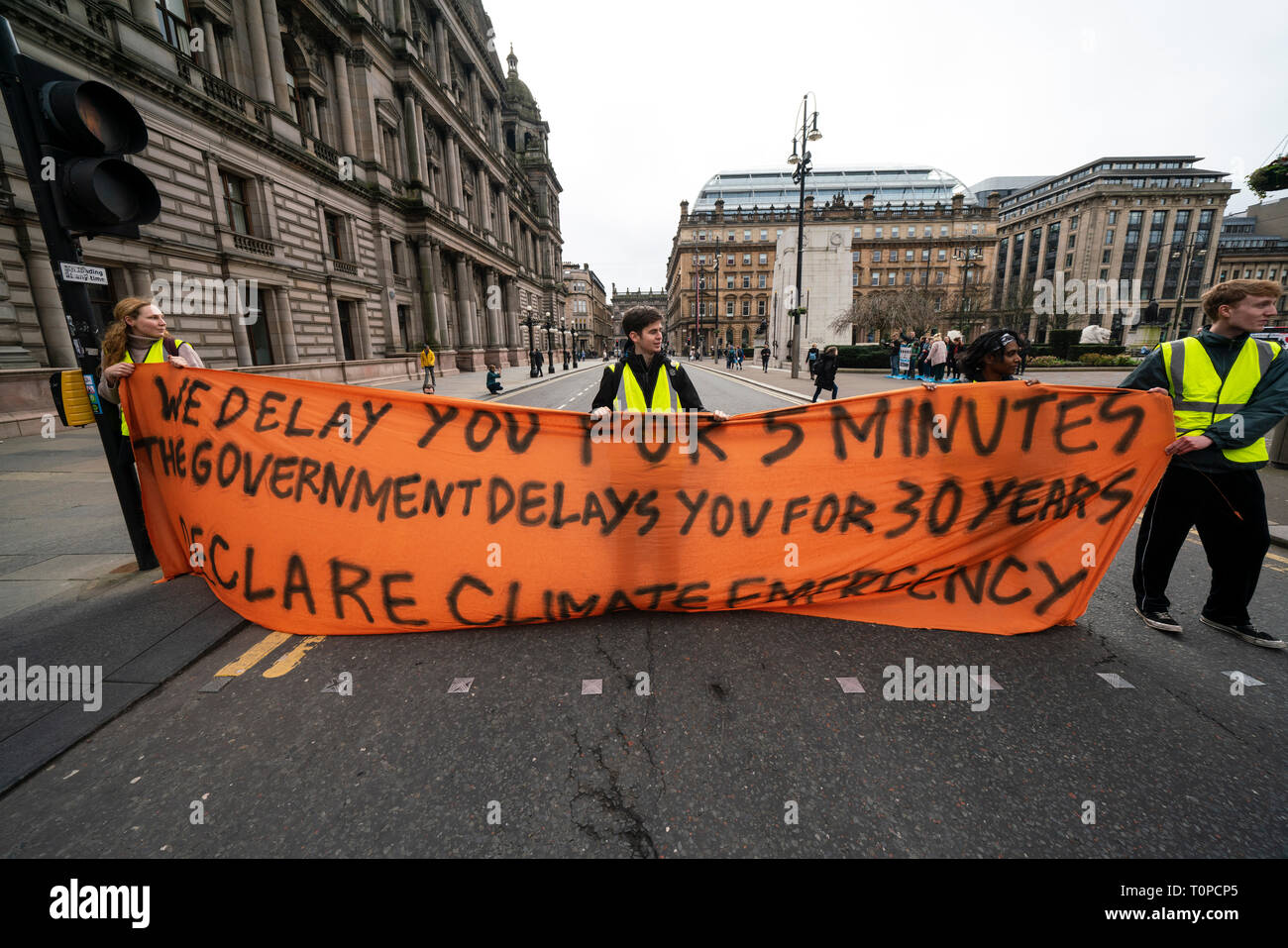 Glasgow, Scotland, UK. 21 March, 2019. A  'Blue Wave' demonstration by the Extinction Rebellion climate change protest group saw protesters make blue footprints, made from water-soluble paint, across George Square to the City Chambers. The peaceful protest briefly held up traffic. The Group aims to highlight threat of rising water levels in the River Clyde and of global climate change. Credit: Iain Masterton/Alamy Live News Stock Photo
