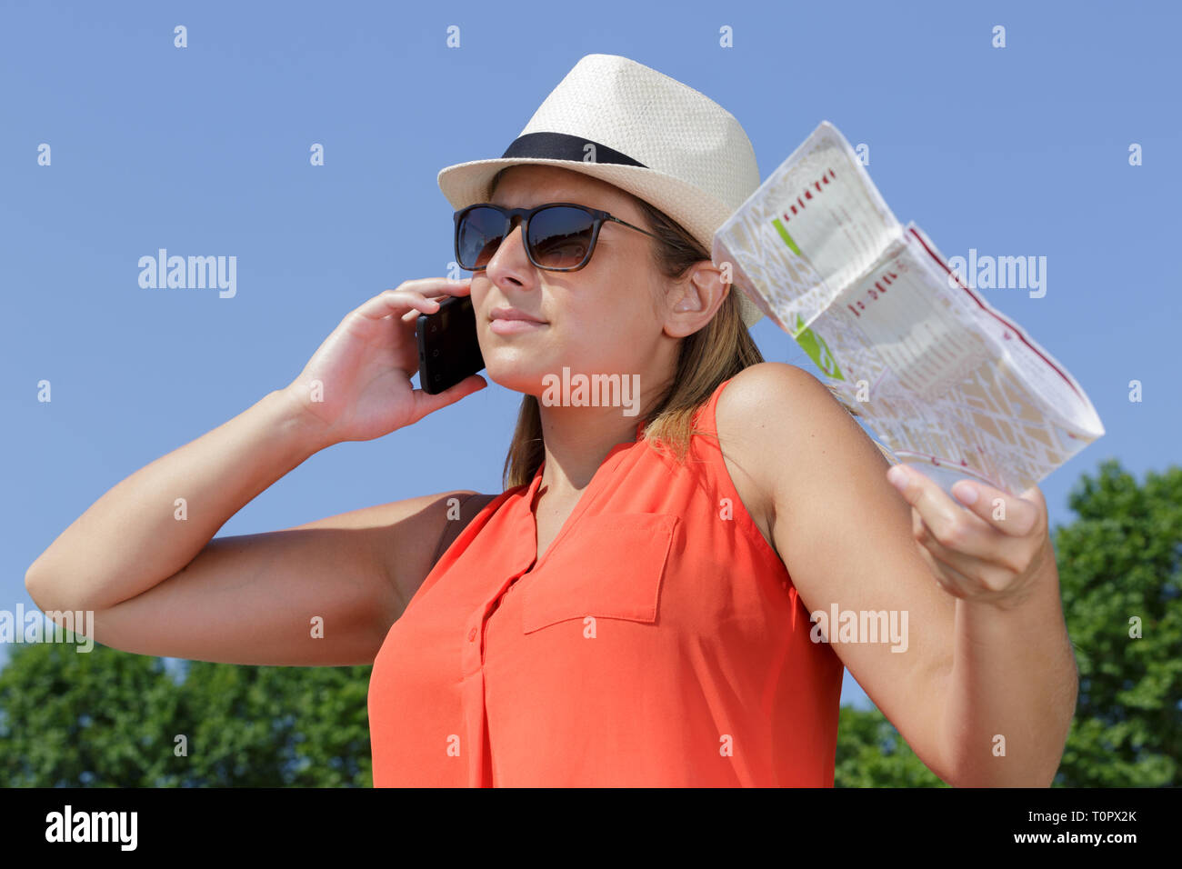 young lady holding map and using smarphone in summer Stock Photo