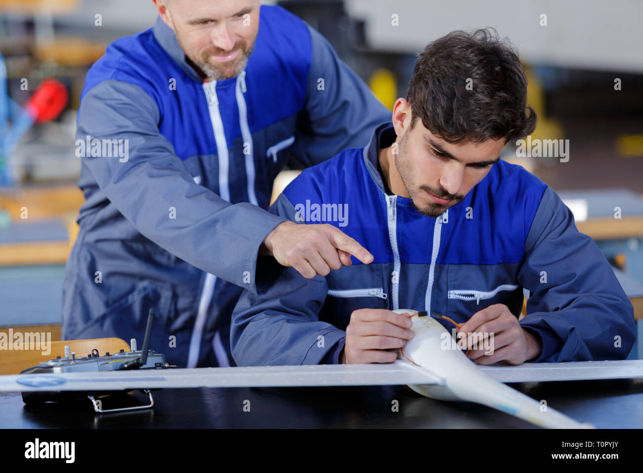 two engineers working in a large aircraft hangar Stock Photo