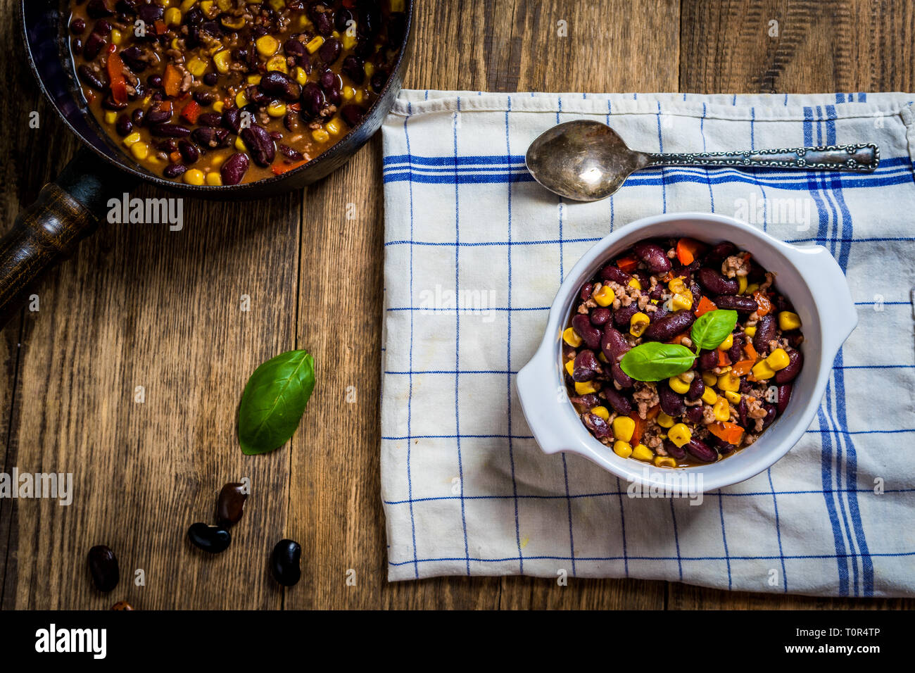 Chili or chilli corn carne. Cooked kidney bean, minced meat, chili, corn and pepper in white bowl  on wood table Stock Photo