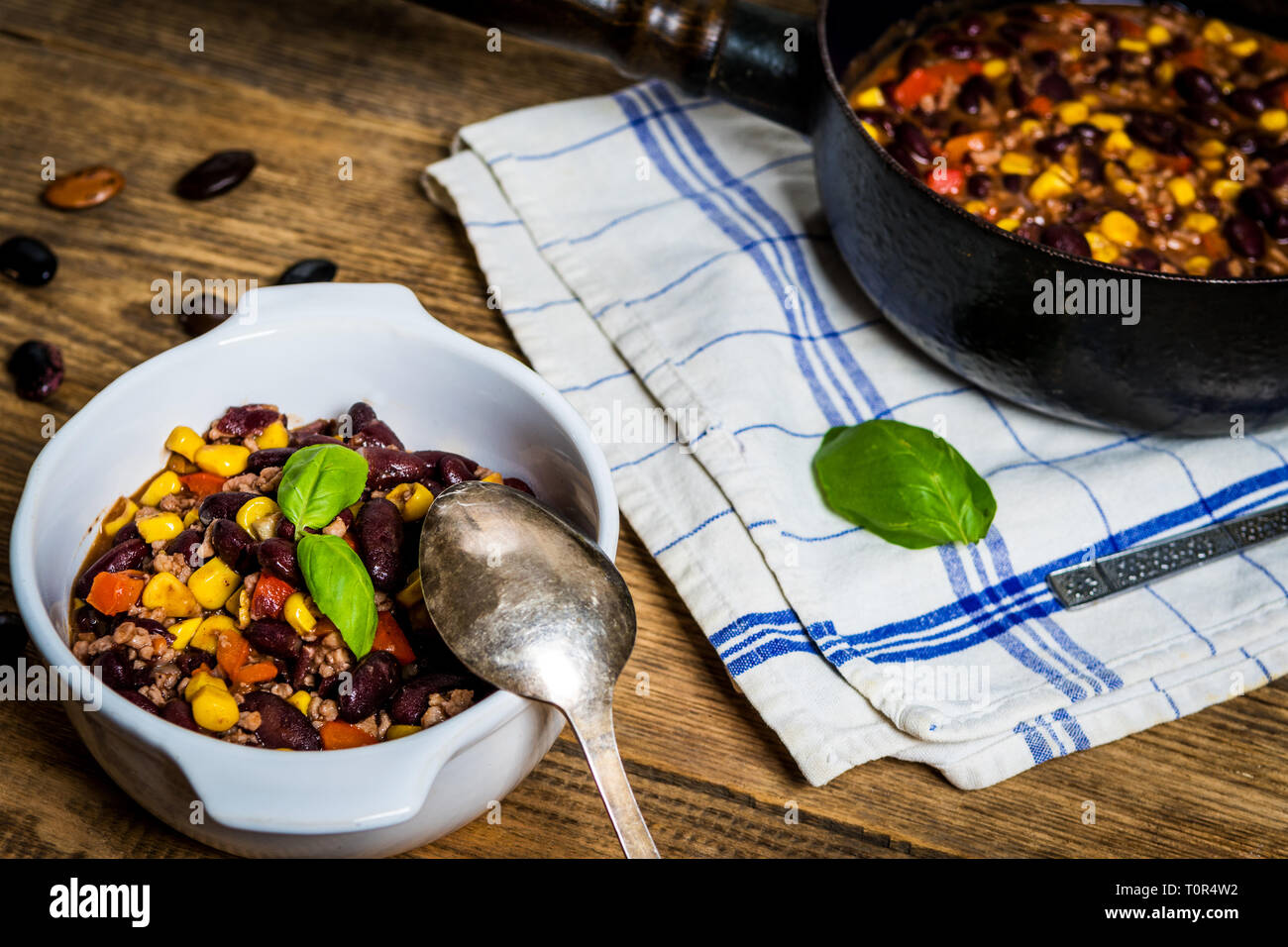 Chili or chilli corn carne. Cooked kidney bean, minced meat, chili, corn and pepper in white bowl  on wood table Stock Photo