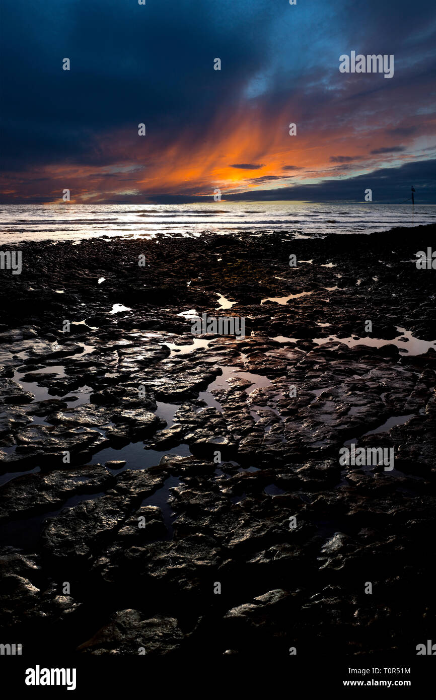 dramatic,gorgeous,sunset,over,sea,geology,strata,erosion,wave,cut,platform,wealden,wessex,vectis,formation,beds,sedimentary,rock,formations,Compton,Ba Stock Photo