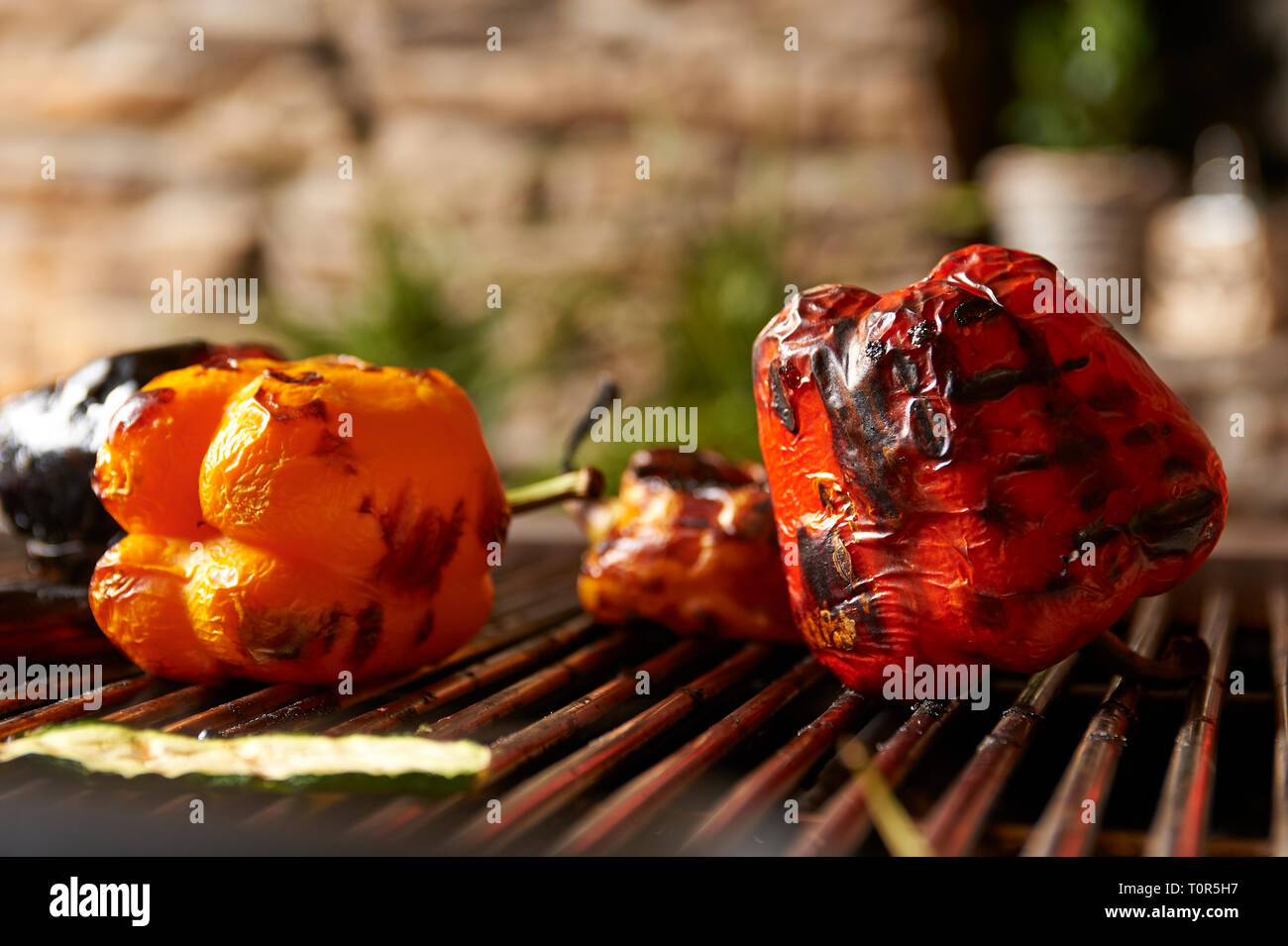 Dunkel gegrillte Paprika liegt auf einem Grillrost auf dem Grill. Stock Photo