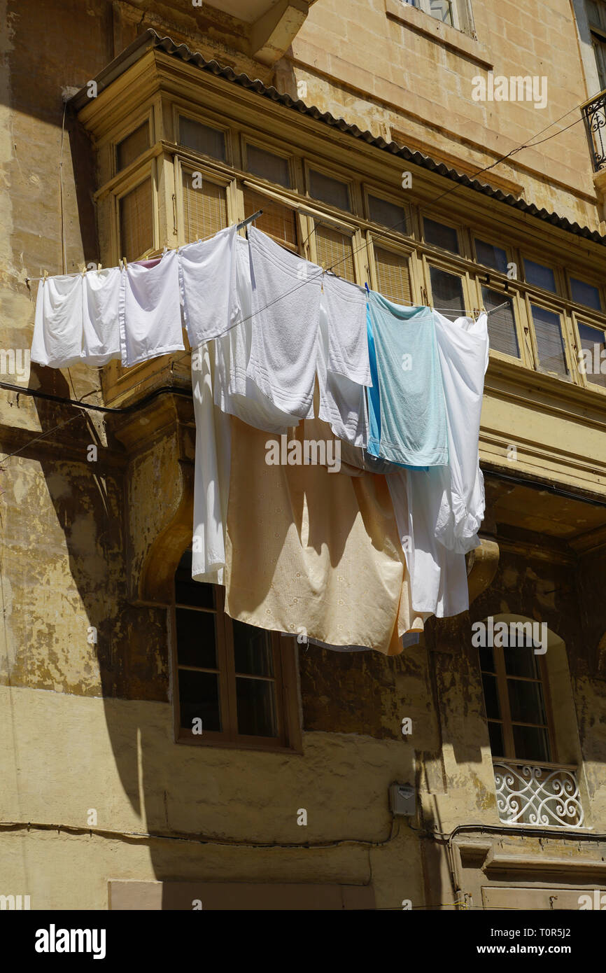 Typical balconies in Malta with suspended laundry for drying Stock Photo