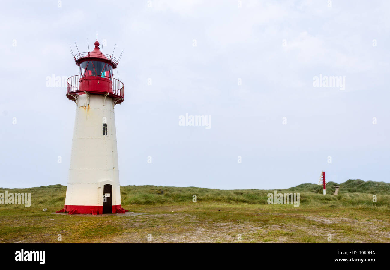 Lighthouse List-West inside a Dune Landscape with grass and sand. Panoramic view on a clear day. Located in List auf Sylt, Schleswig-Holstein, Germany Stock Photo