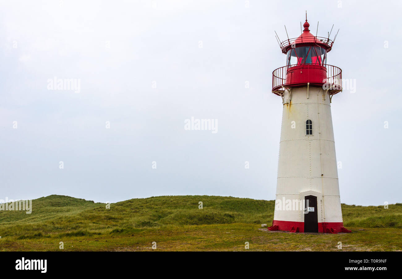 Lighthouse List-West inside a Dune Landscape with grass and sand. Detail view on a clear day. Located in List auf Sylt, Schleswig-Holstein, Germany. Stock Photo