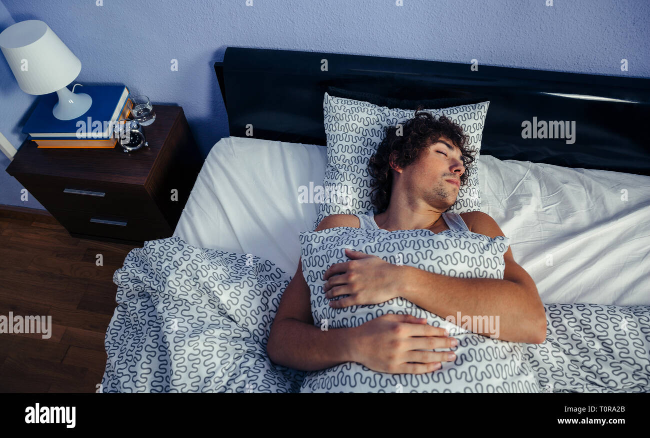 Man sleeping in bed at home Stock Photo