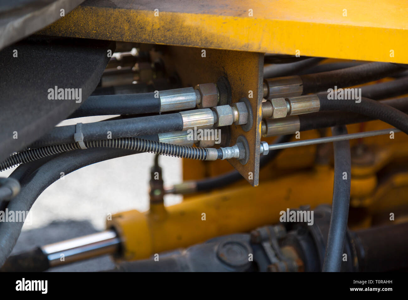 Hydraulic system hoses connections and bitumenstained details of